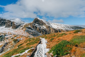 a snow covered mountain with a trail going through it