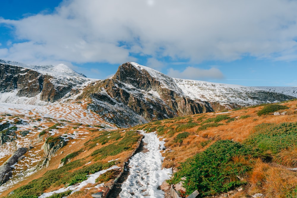 a snow covered mountain with a trail going through it