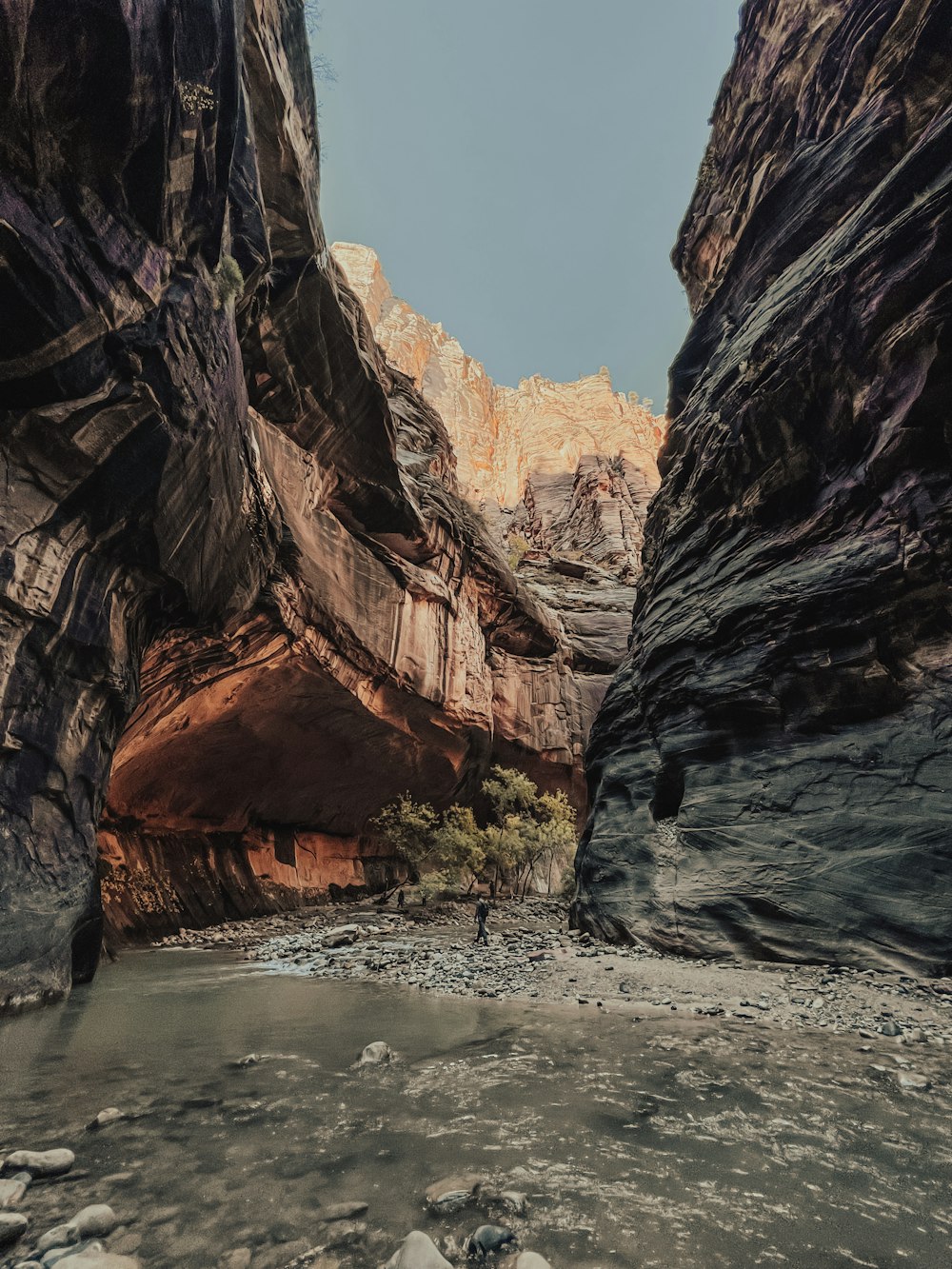 a man standing in the middle of a narrow canyon