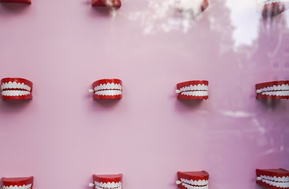 a pink wall with white teeth and braces on it