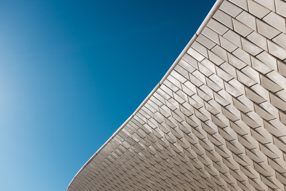 Ein Gebäude mit geschwungenem Dach und blauem Himmel im Hintergrund