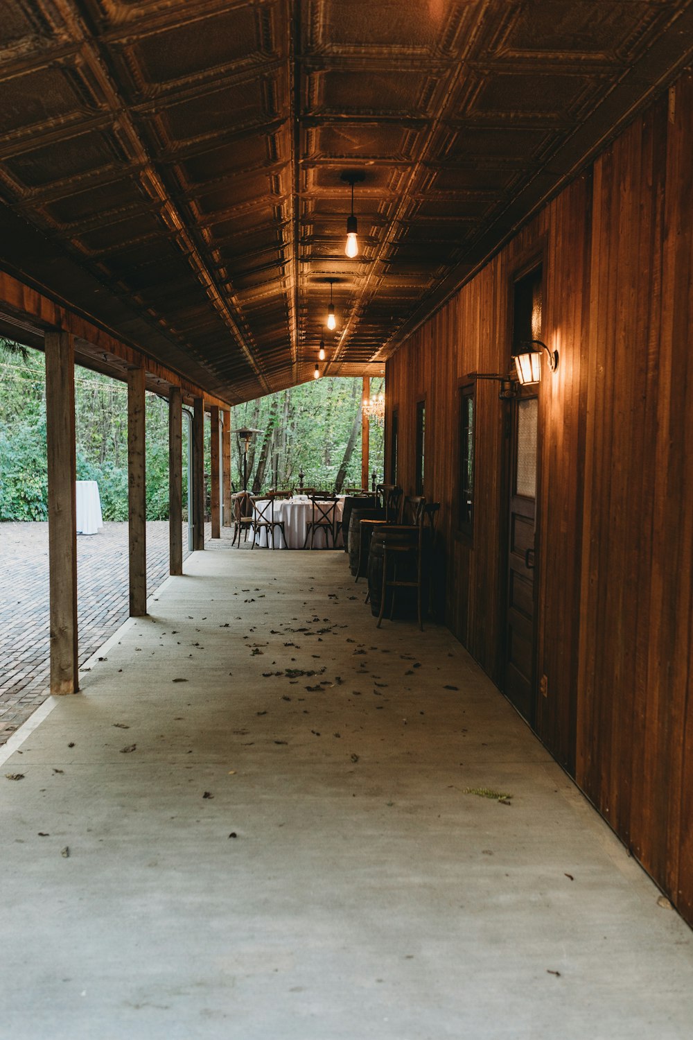 a long covered walkway with tables and chairs