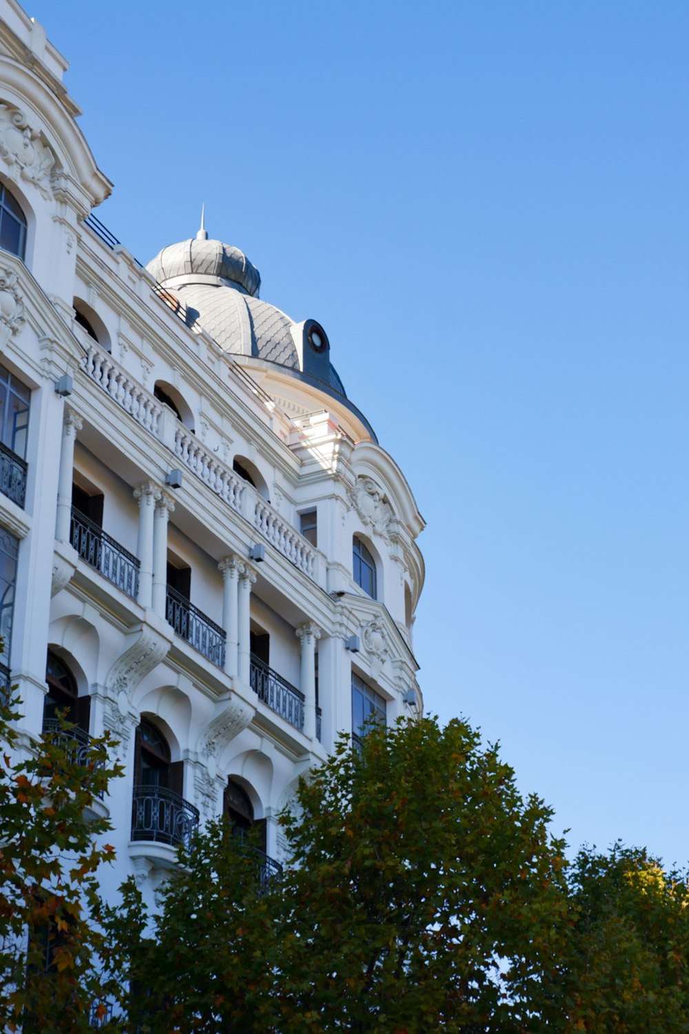 a large white building with a clock on the front of it