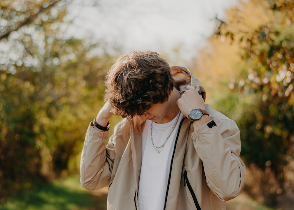 Un uomo con una giacca marrone chiaro si tiene le mani alle orecchie foto –  Sorgenti termali Immagine gratuita su Unsplash
