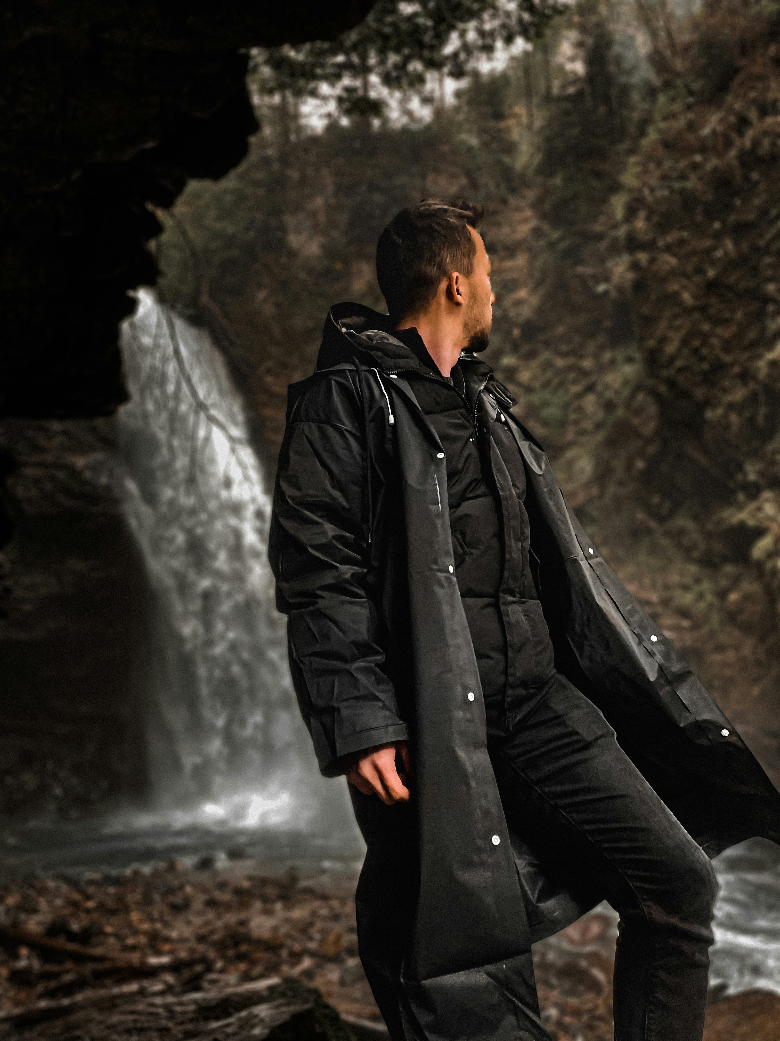 a man standing in front of a waterfall