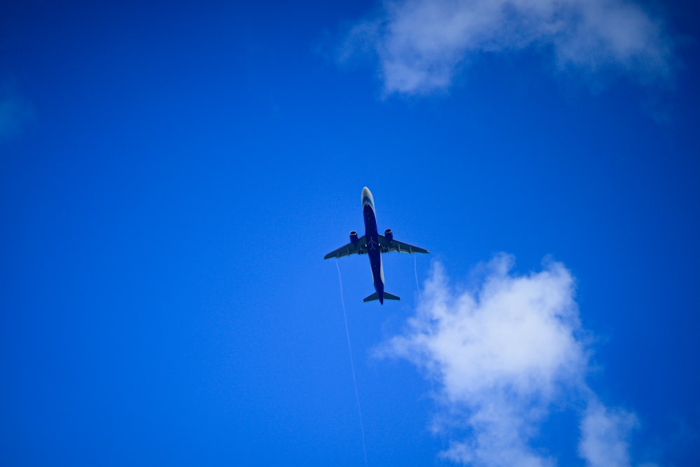 an airplane is flying through the blue sky