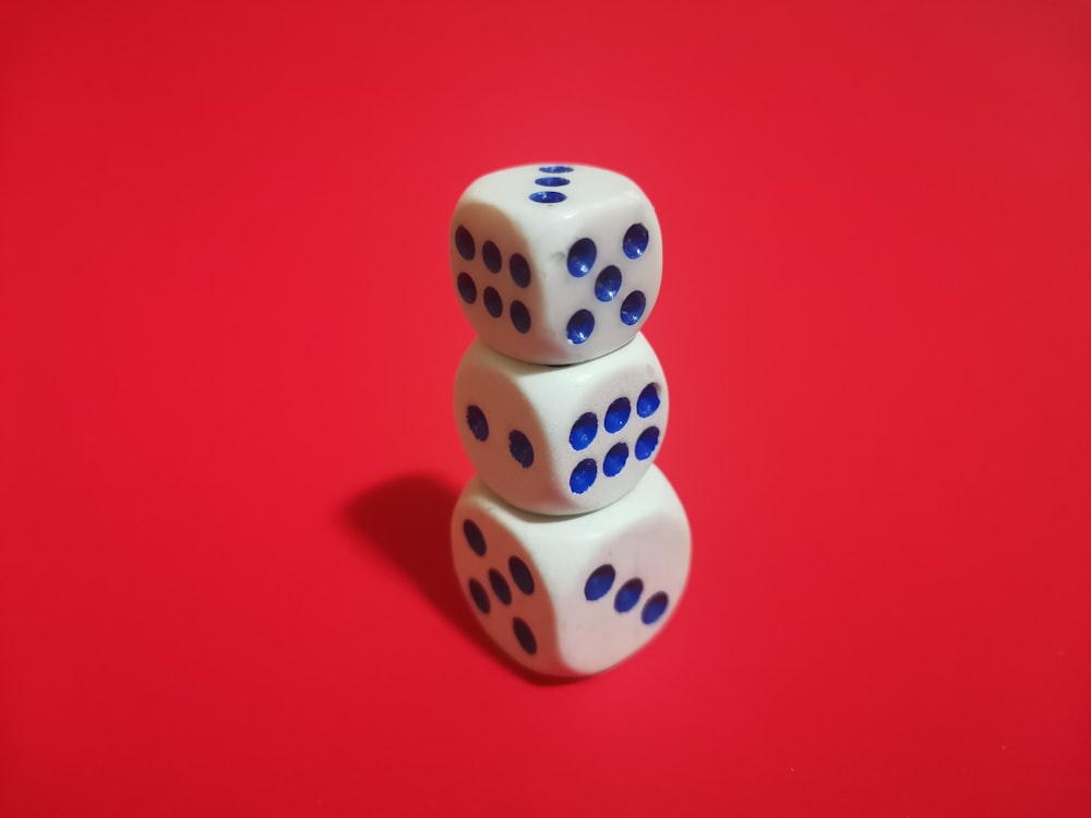 two dices stacked on top of each other on a red surface