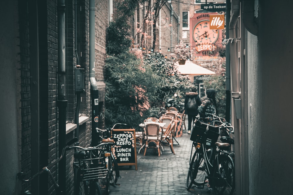 a narrow alleyway with tables and chairs and a clock on the wall