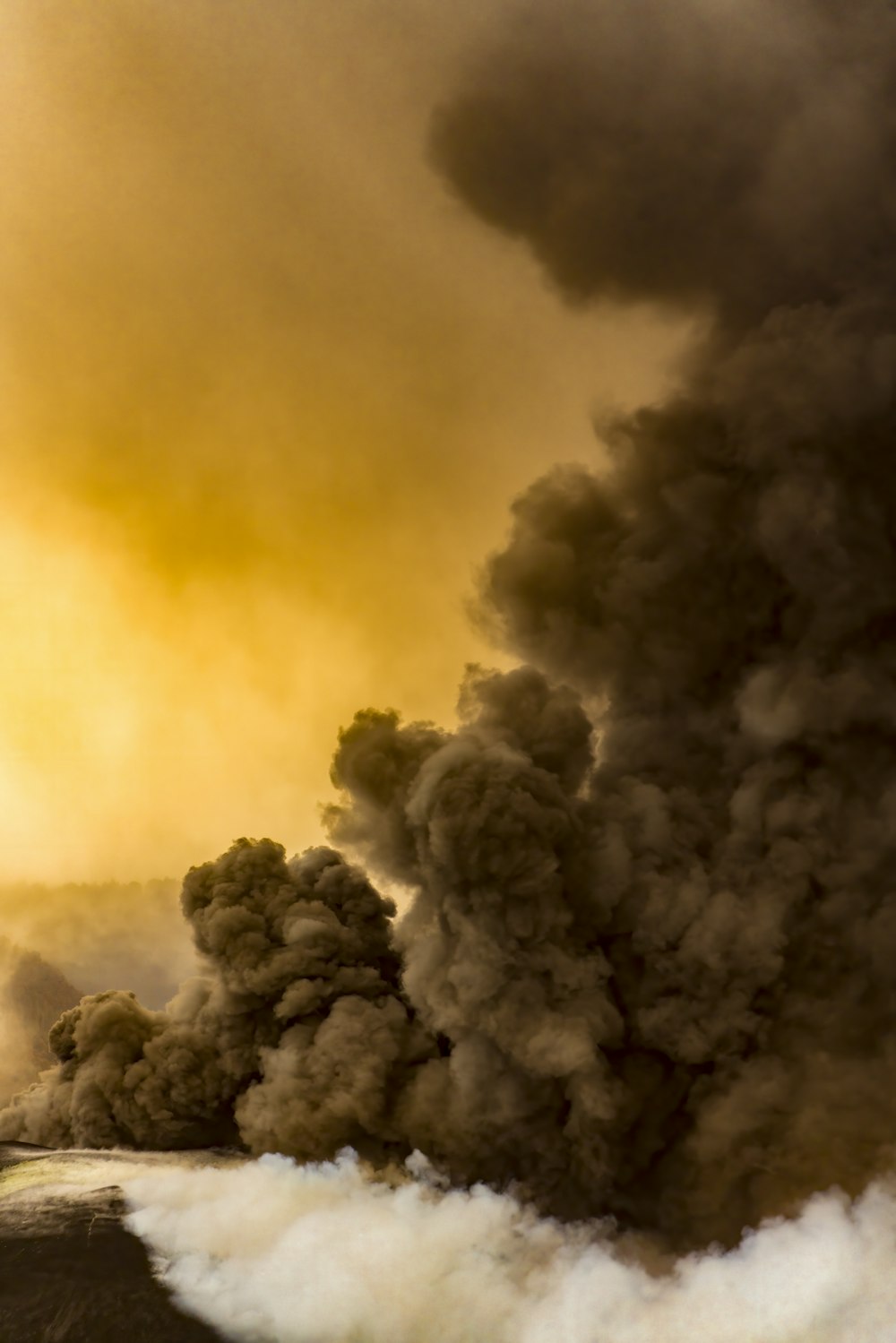 a large plume of black smoke billowing out of the sky