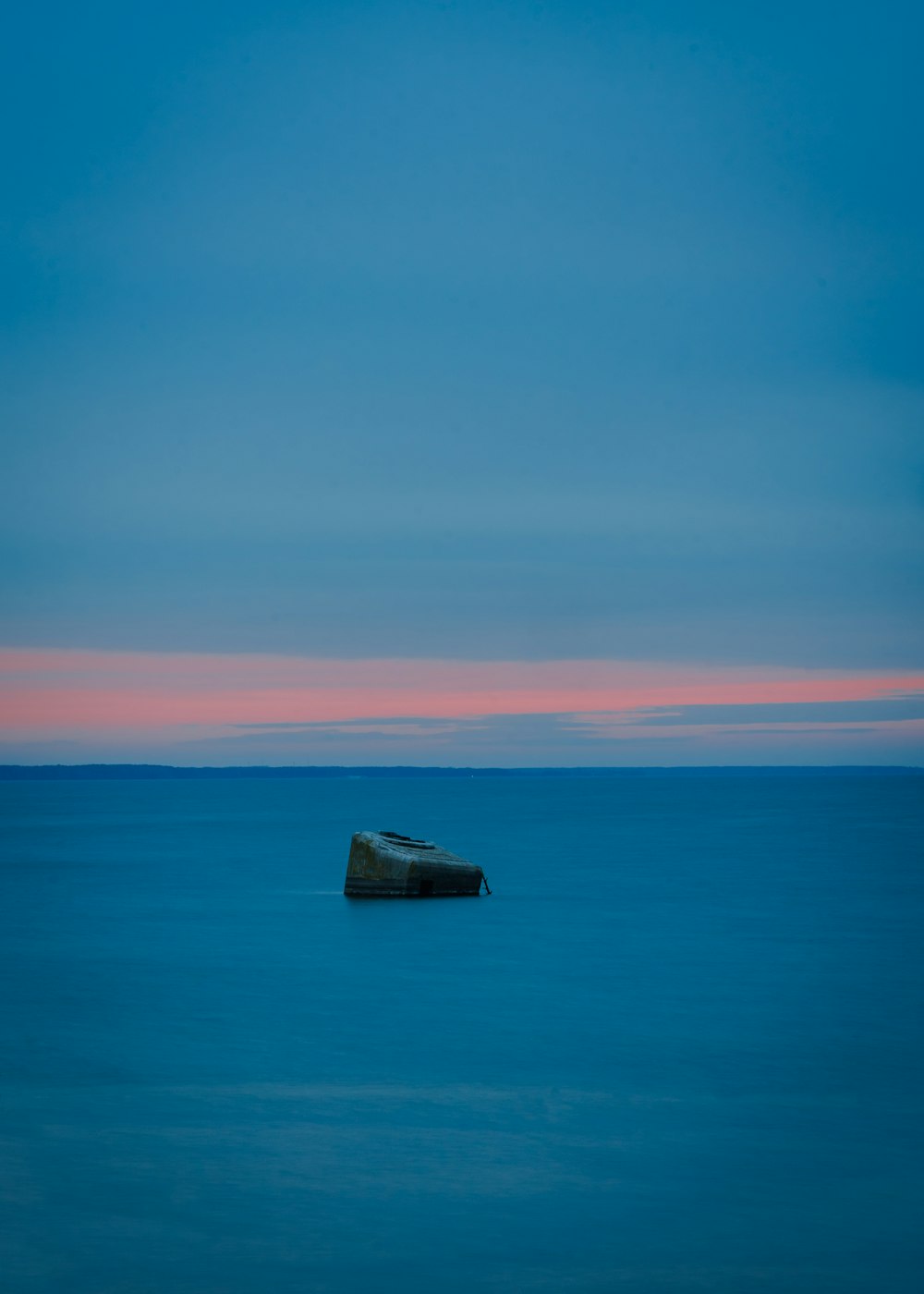 a small boat floating on top of a large body of water