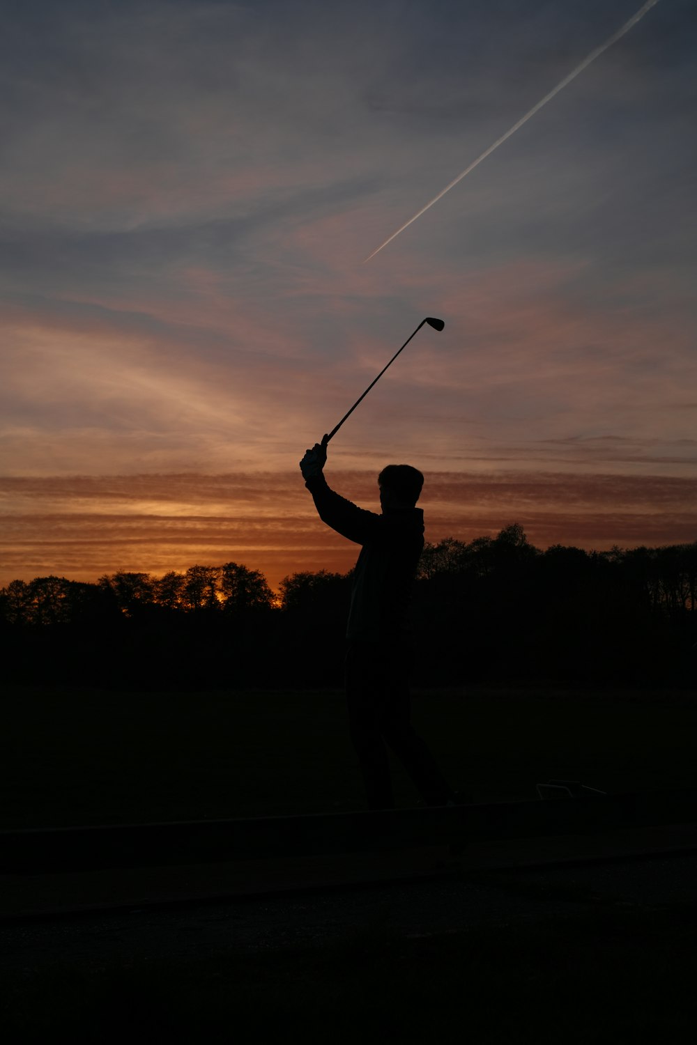 una silueta de un hombre sosteniendo un palo de golf