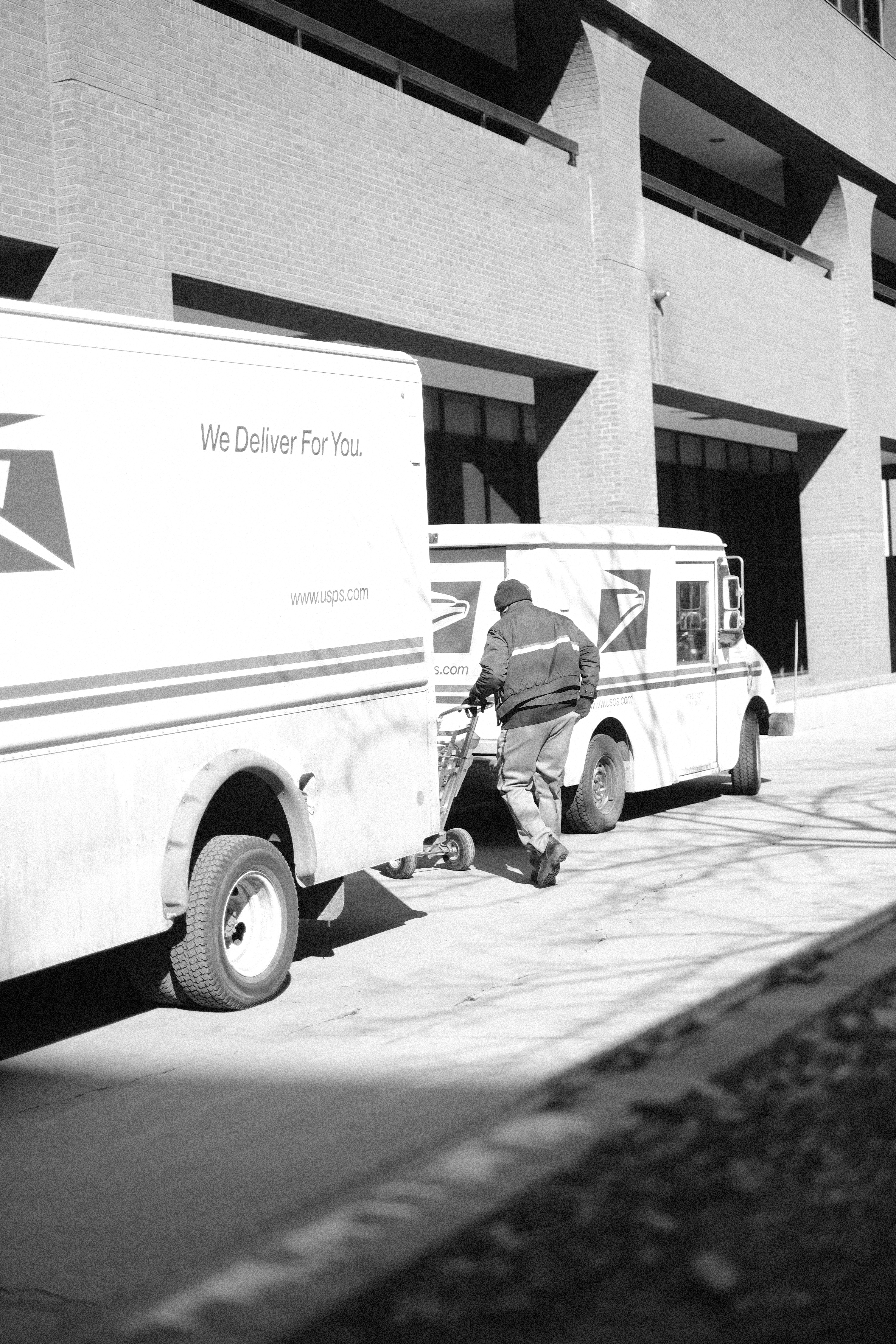 a black and white photo of a delivery truck