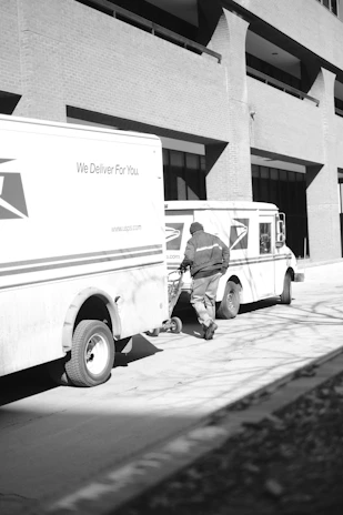 a black and white photo of a delivery truck
