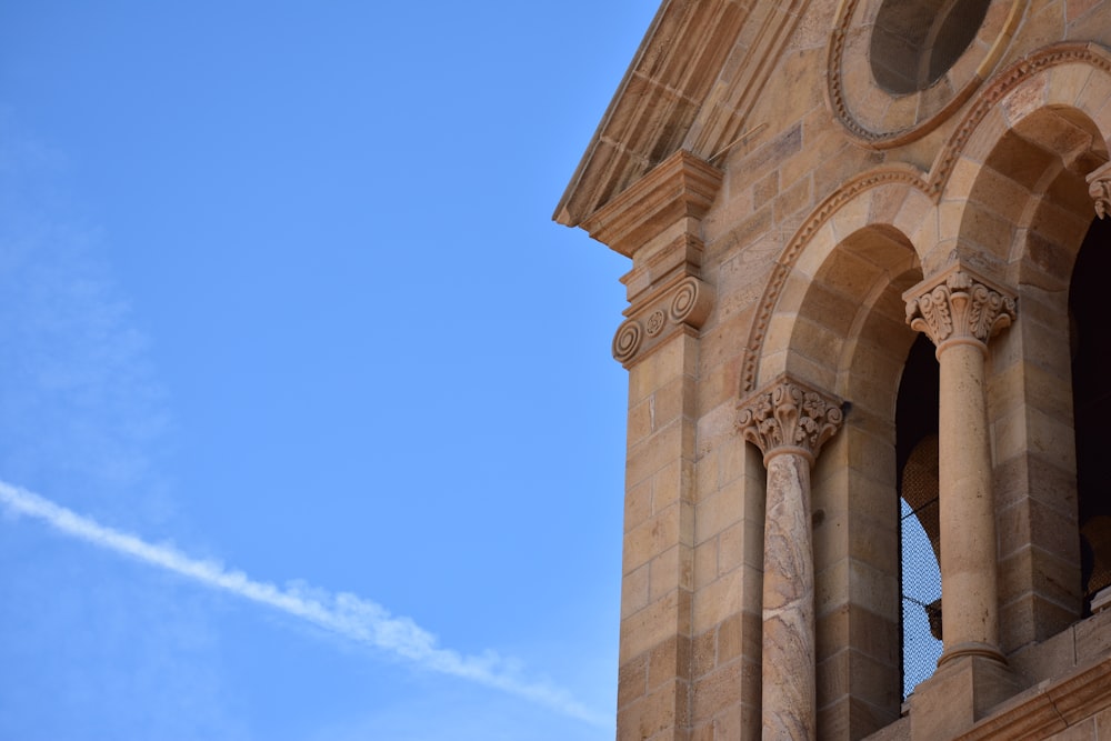 a plane flying in the sky over a building