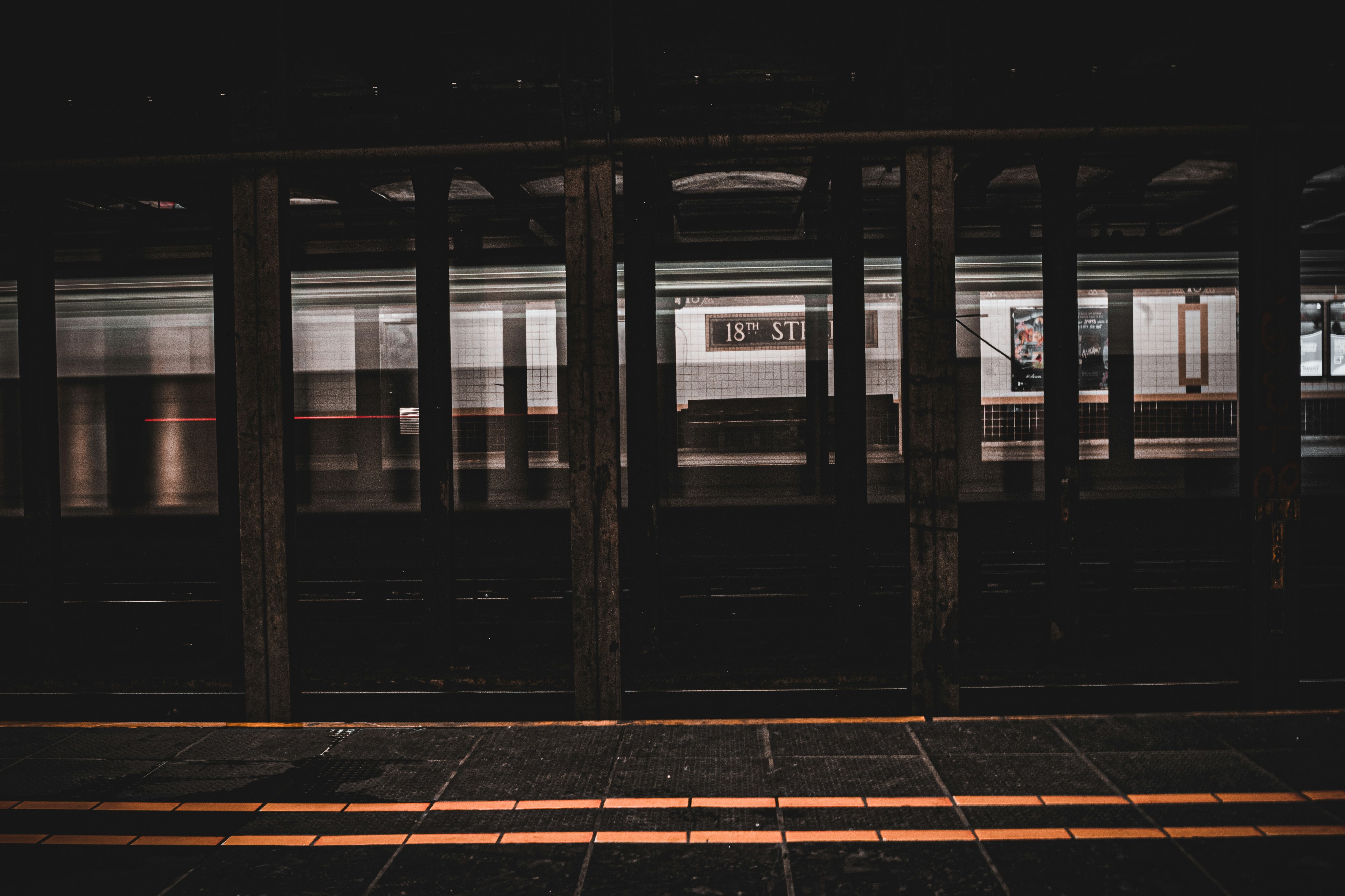 a train station with a train passing by at night