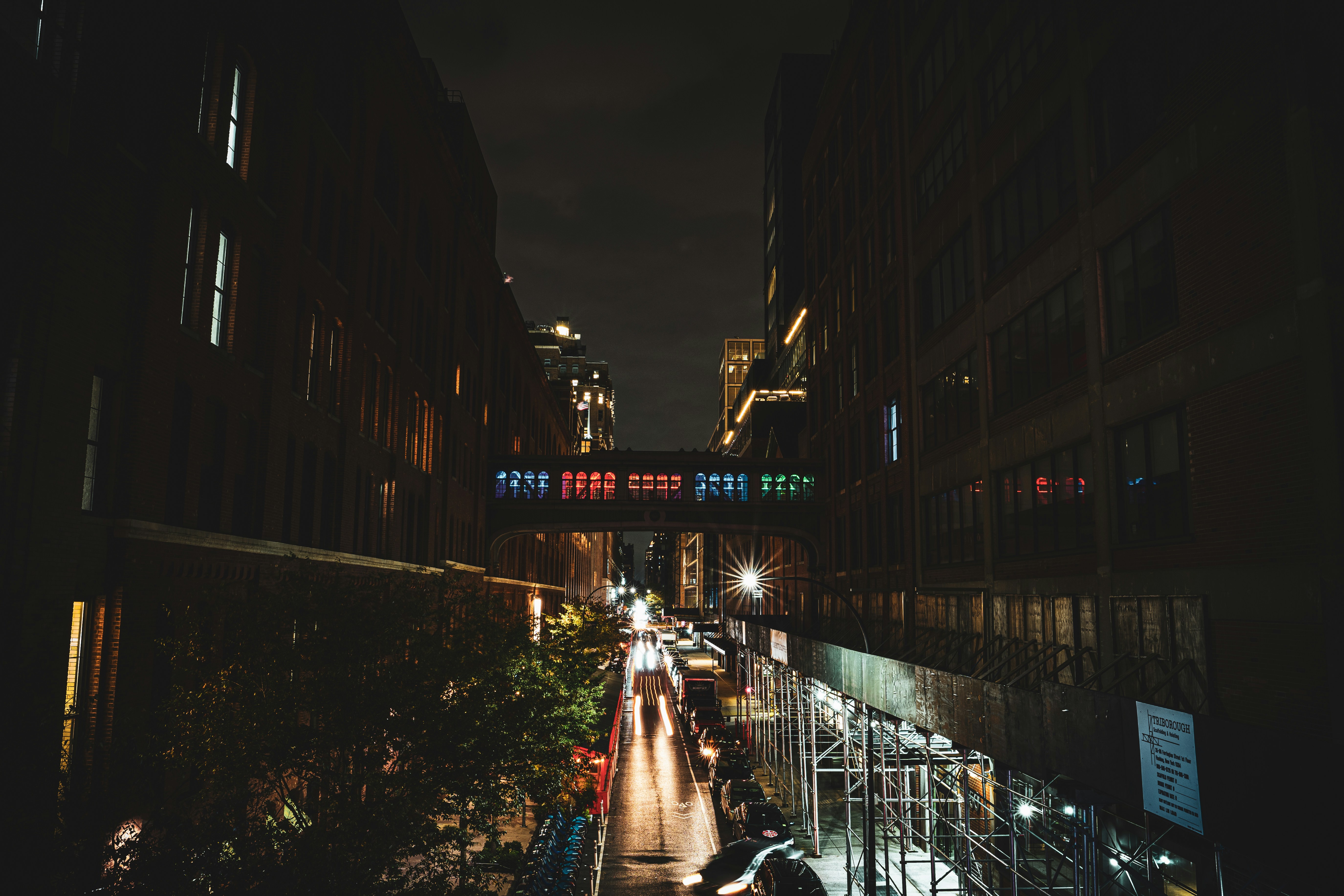 a city street at night with people walking on the sidewalk