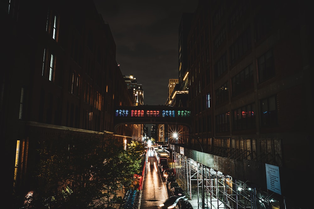 a city street at night with people walking on the sidewalk