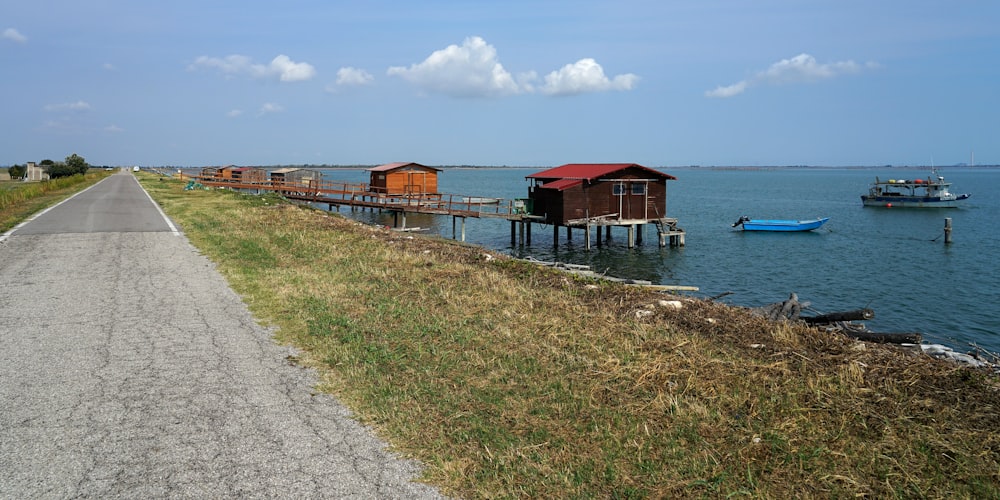 a boat dock on the side of a road next to a body of water