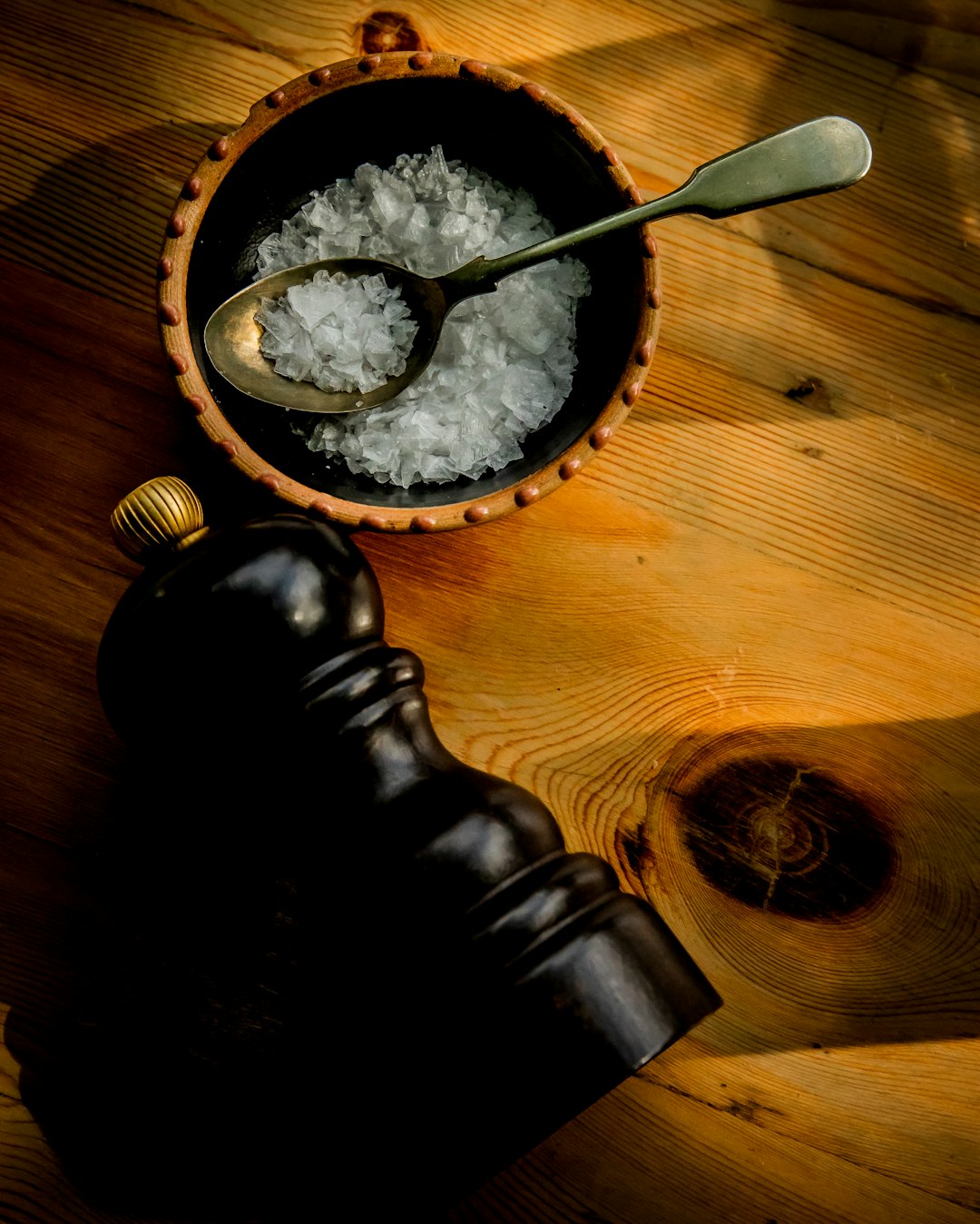 a wooden bowl filled with white rice next to a bottle
