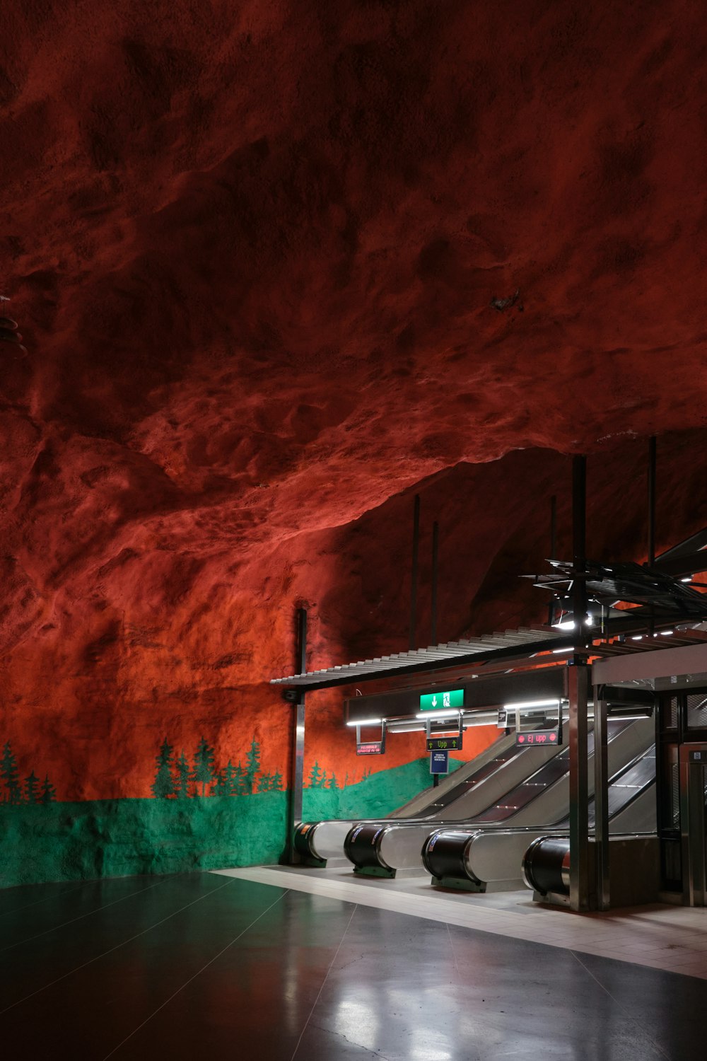 an empty subway station with red and green walls