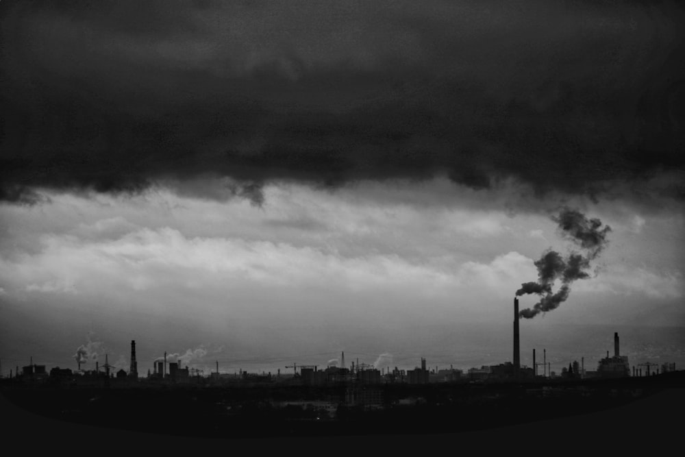 uma foto em preto e branco de uma fábrica com fumaça saindo dela