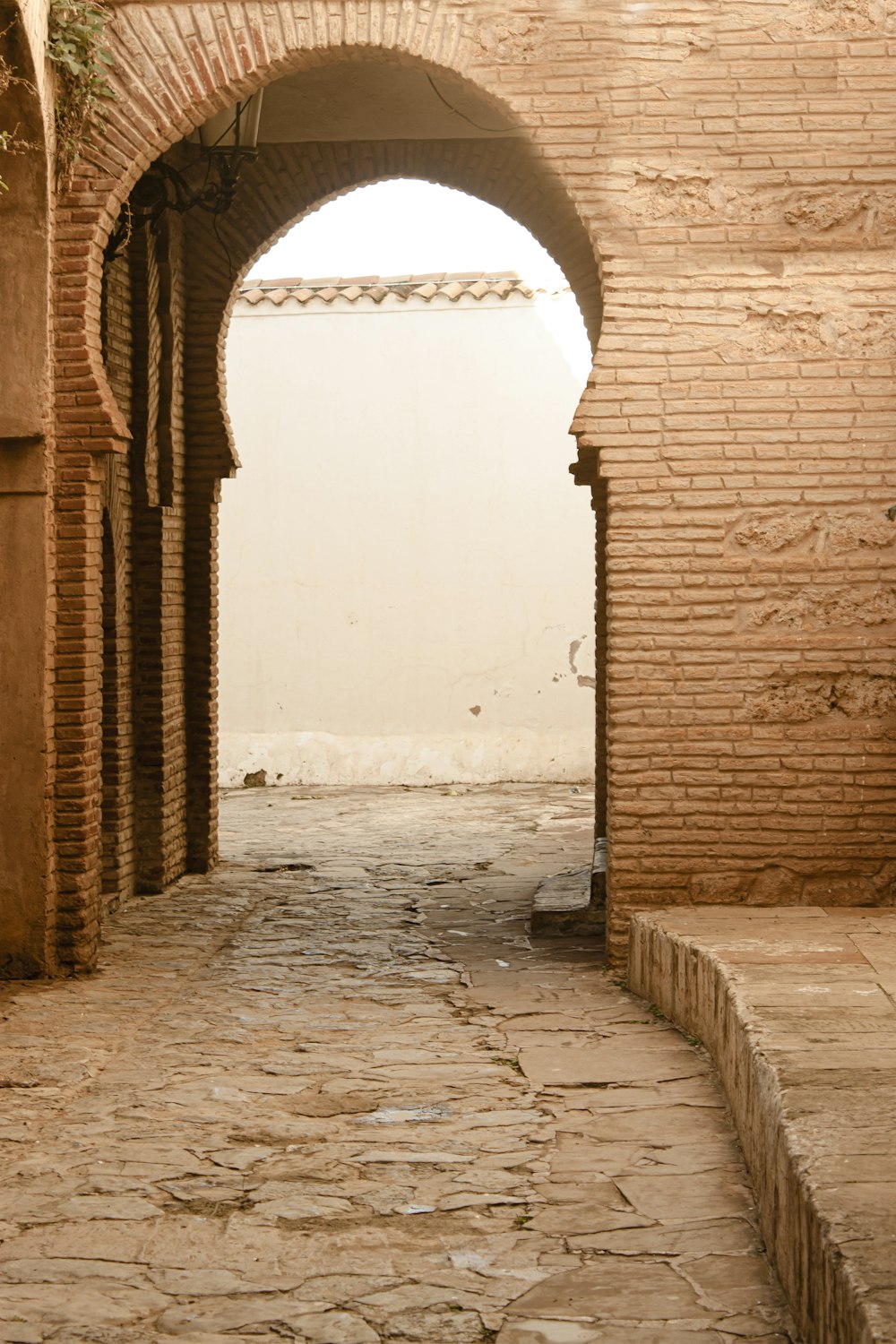 an archway in a brick building with a clock on it