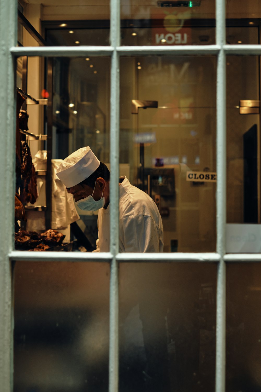 a man wearing a white hat and a white coat in a kitchen