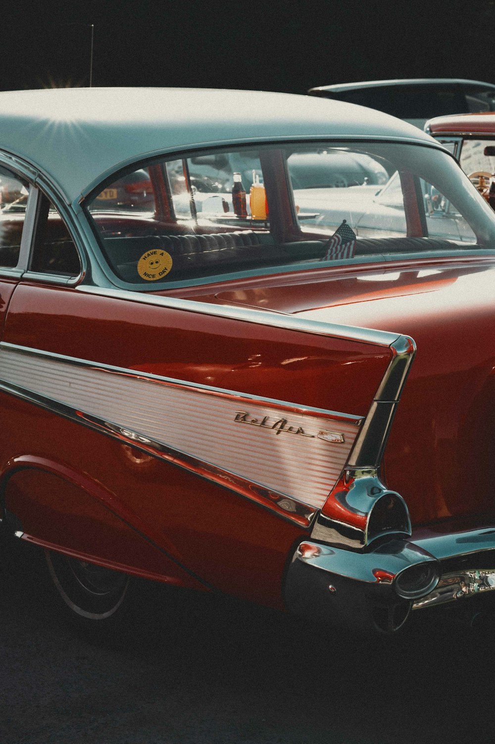 an old red car parked in a parking lot