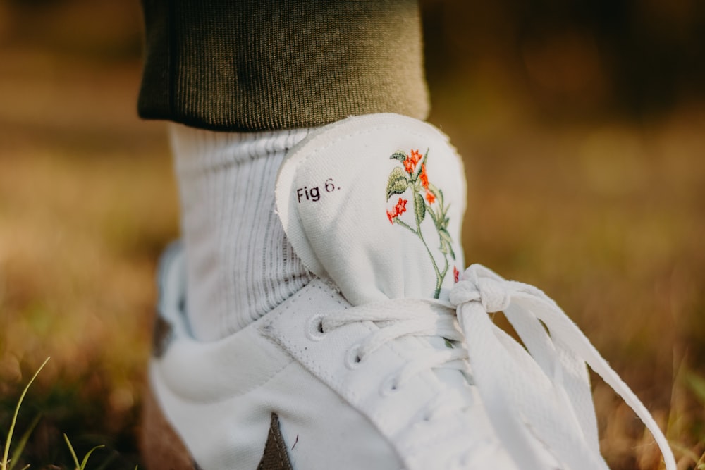 a close up of a person's shoes with flowers on them