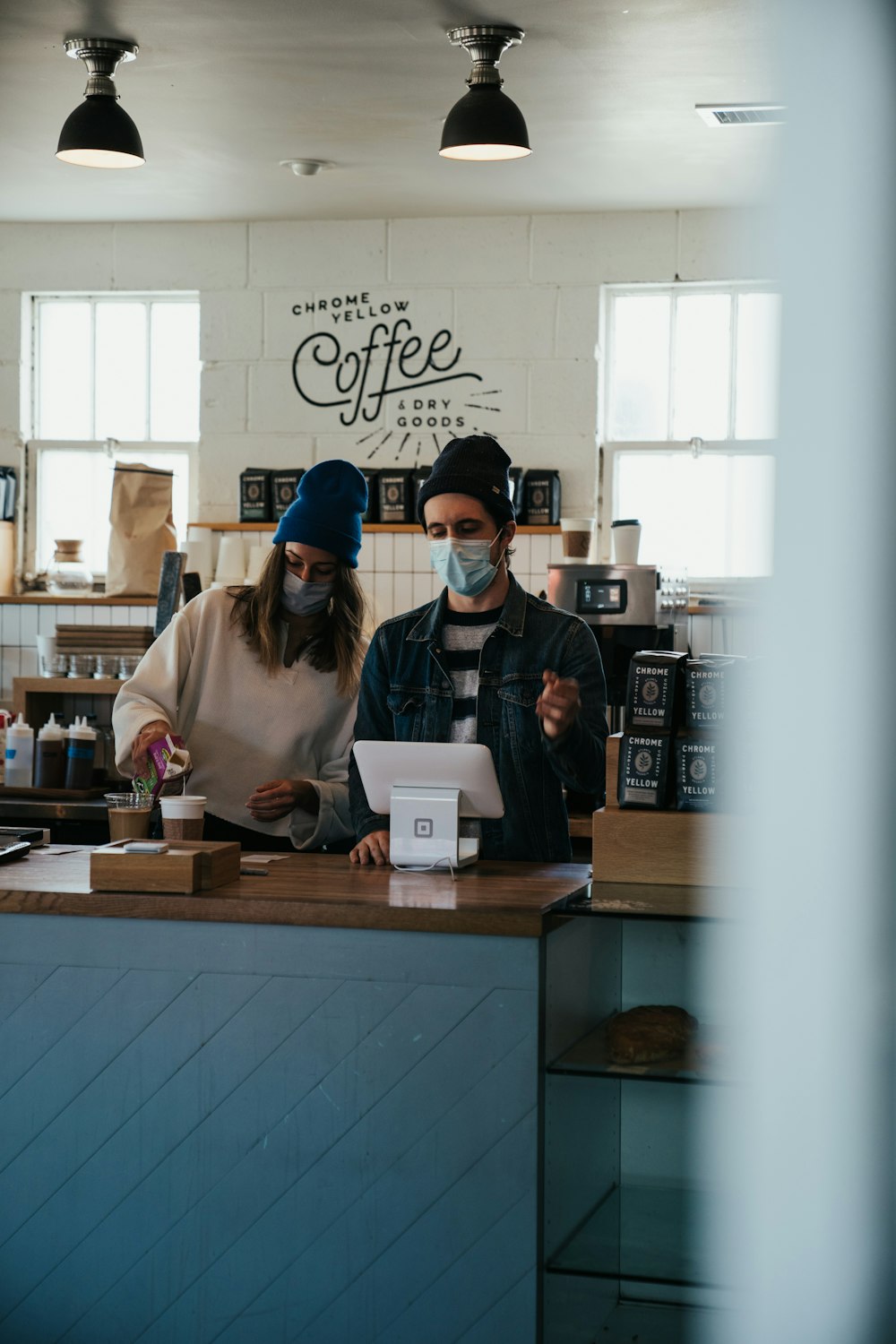 a man and a woman standing at a counter in a coffee shop