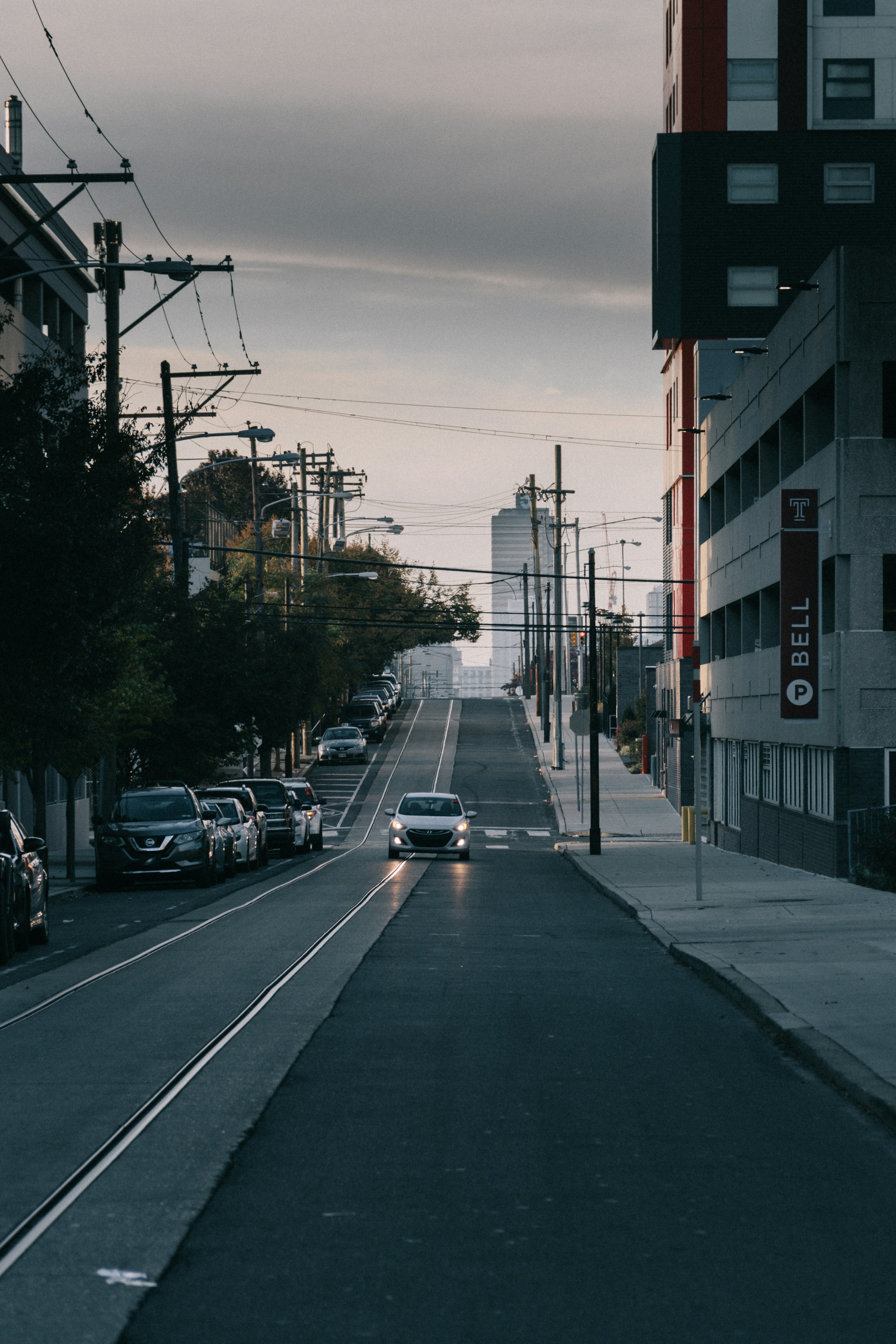 Un coche conduciendo por una calle junto a edificios altos