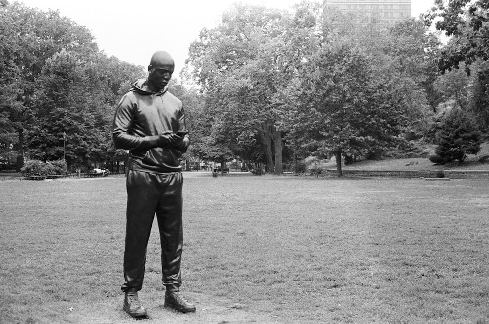 a black and white photo of a man standing in a park