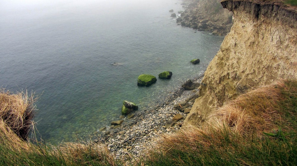 a view of the ocean from a cliff on a foggy day