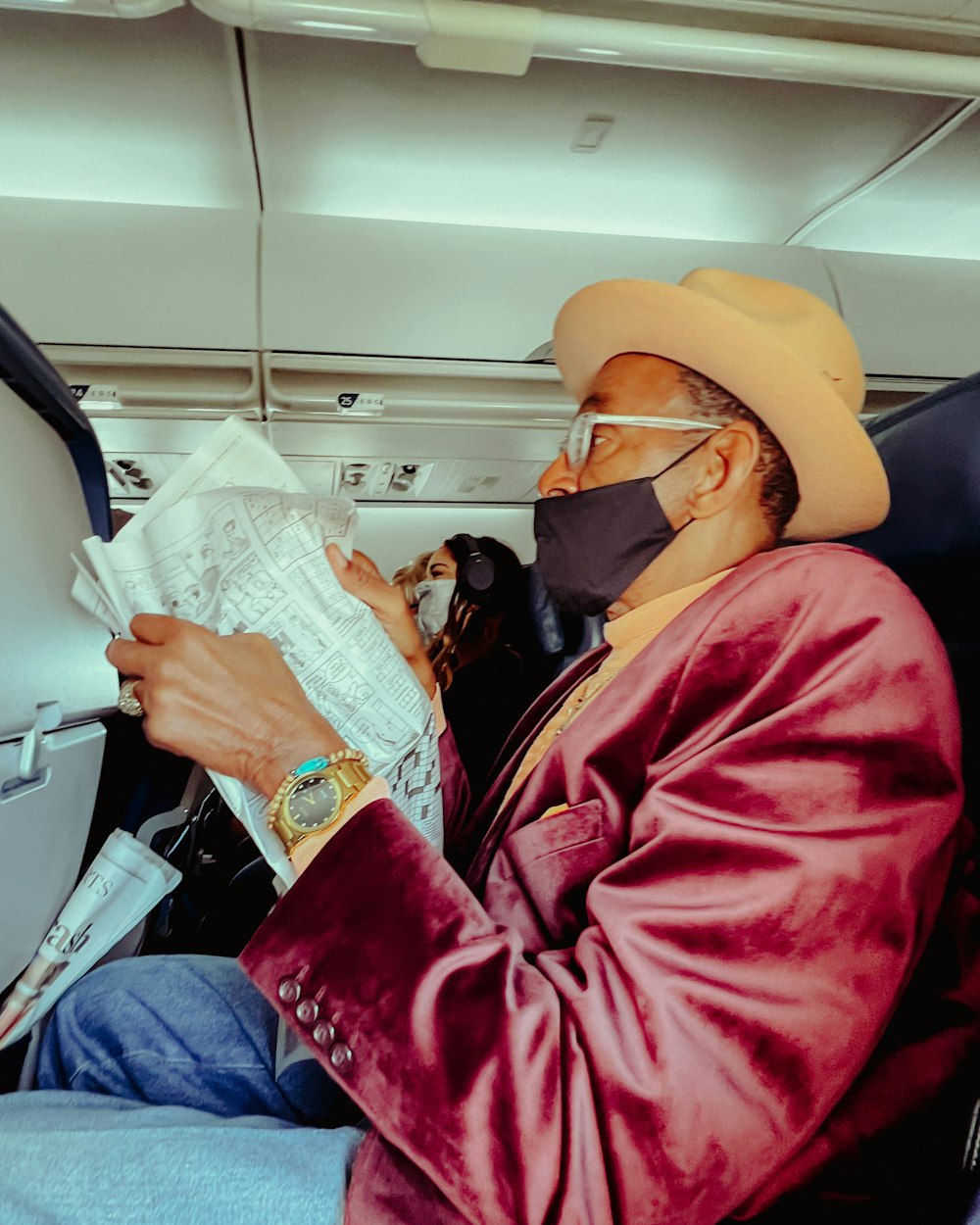 a man wearing a face mask while sitting in an airplane