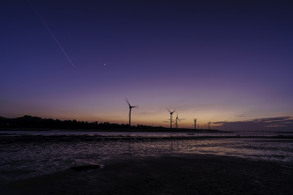 Wind turbines on a beach on the Miaoli coast under a purple dusk sky