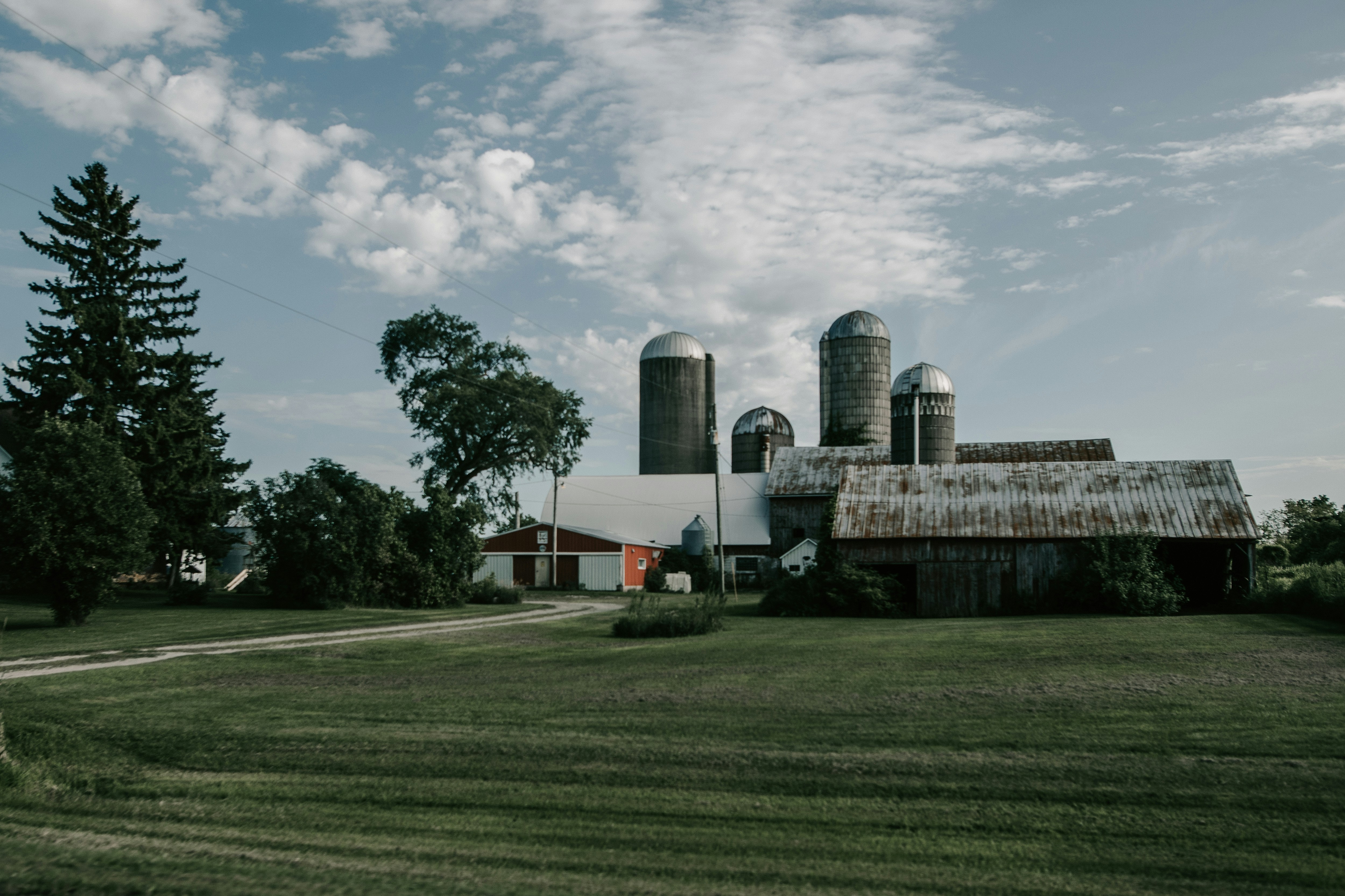 a farm with a barn and silos in the background