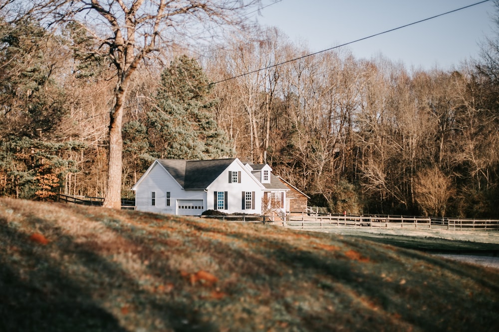 a white house sitting on top of a lush green hillside