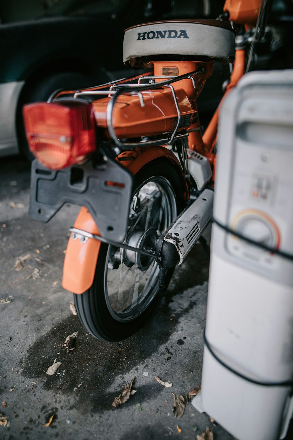 an orange motorcycle parked next to a cooler