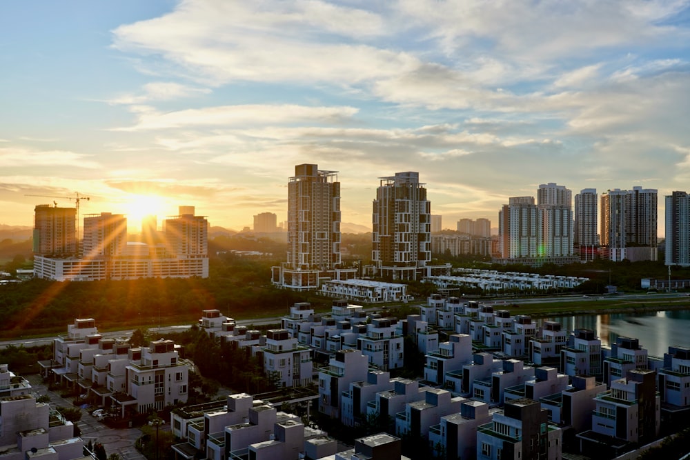 the sun is setting over a city with tall buildings