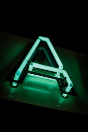 a triangle shaped neon sign sitting on top of a table