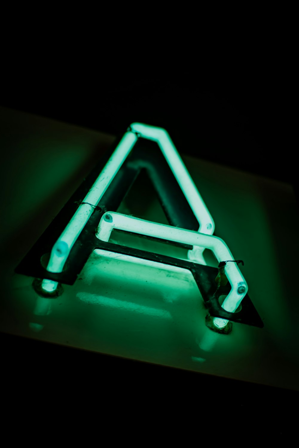 a triangle shaped neon sign sitting on top of a table