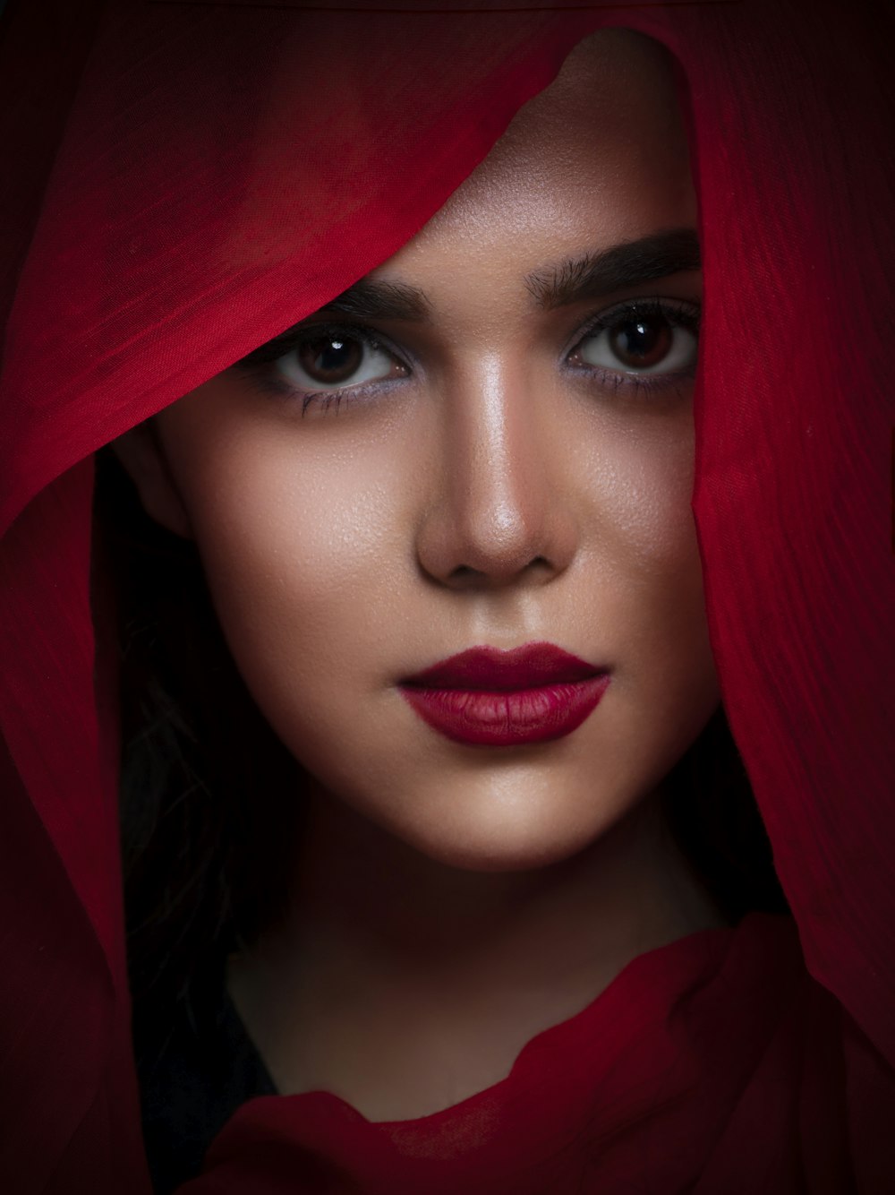a woman with a red veil on her head