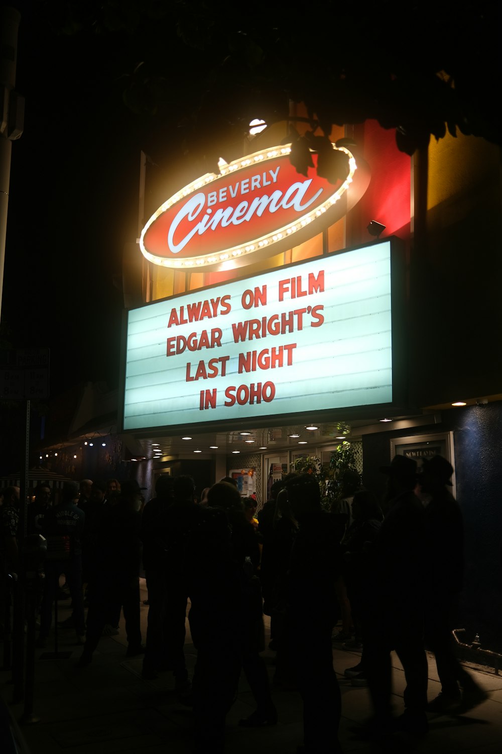 a crowd of people standing outside of a theater