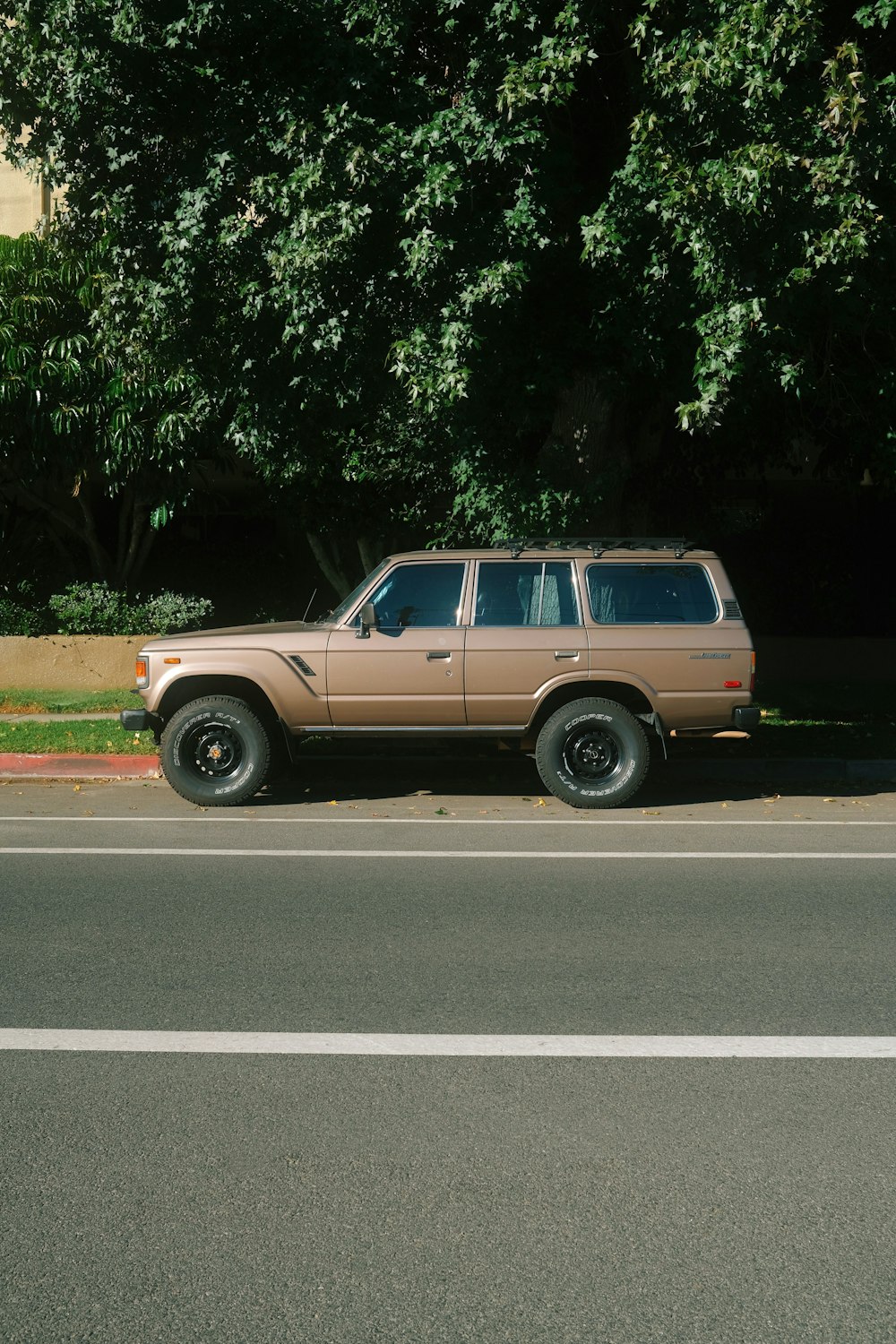 a brown suv parked on the side of the road