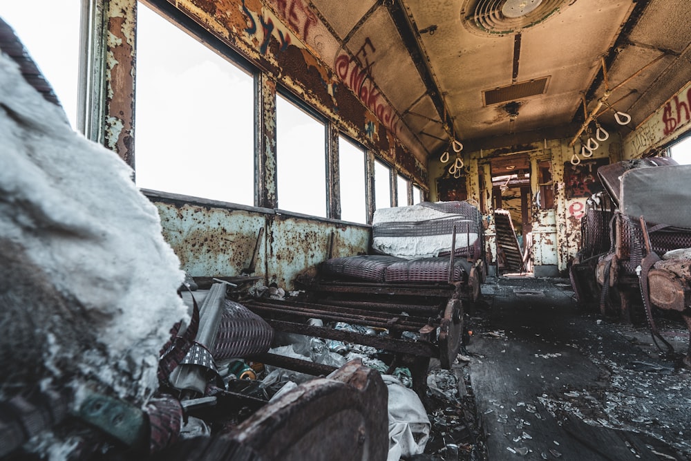 an abandoned train car filled with lots of furniture