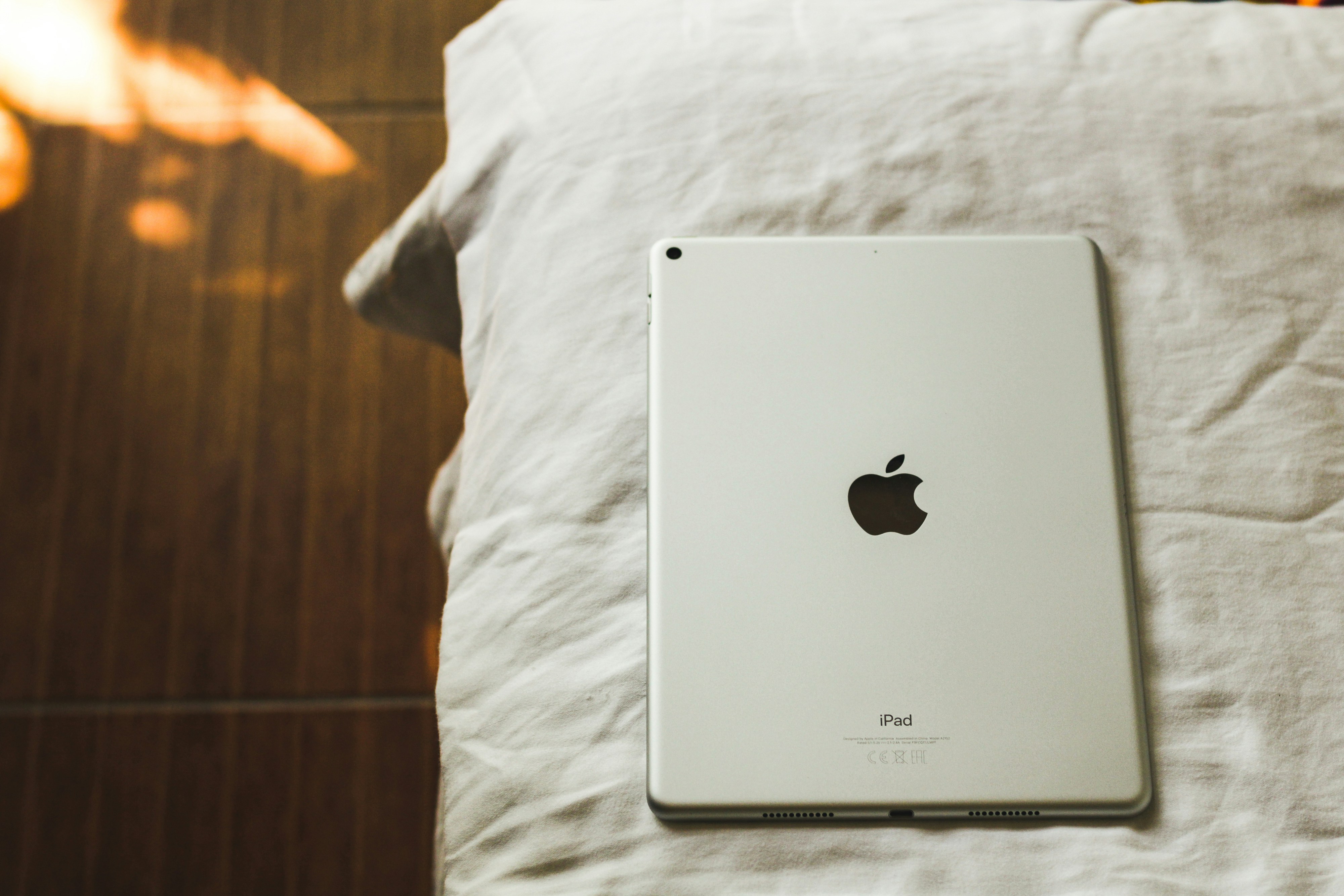 Silver Apple iPad resting on white fabric