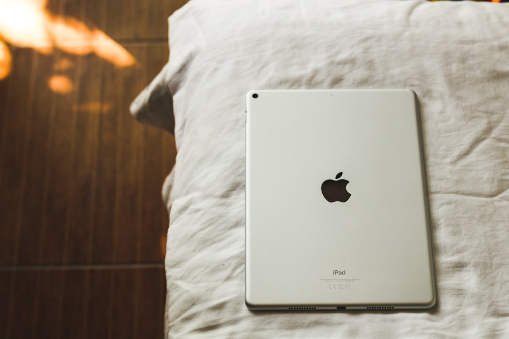 an apple ipad sitting on top of a bed