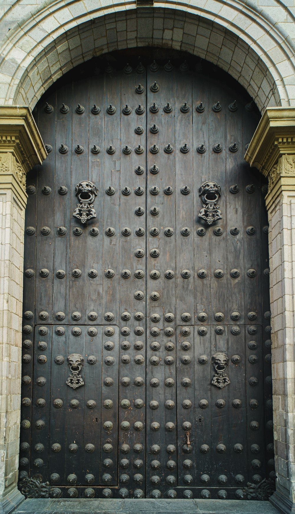 a large metal door with a lion head on it