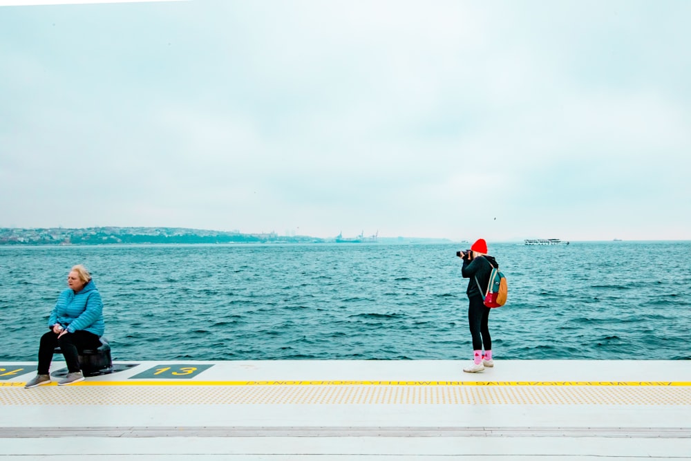 a couple of people that are sitting on a dock