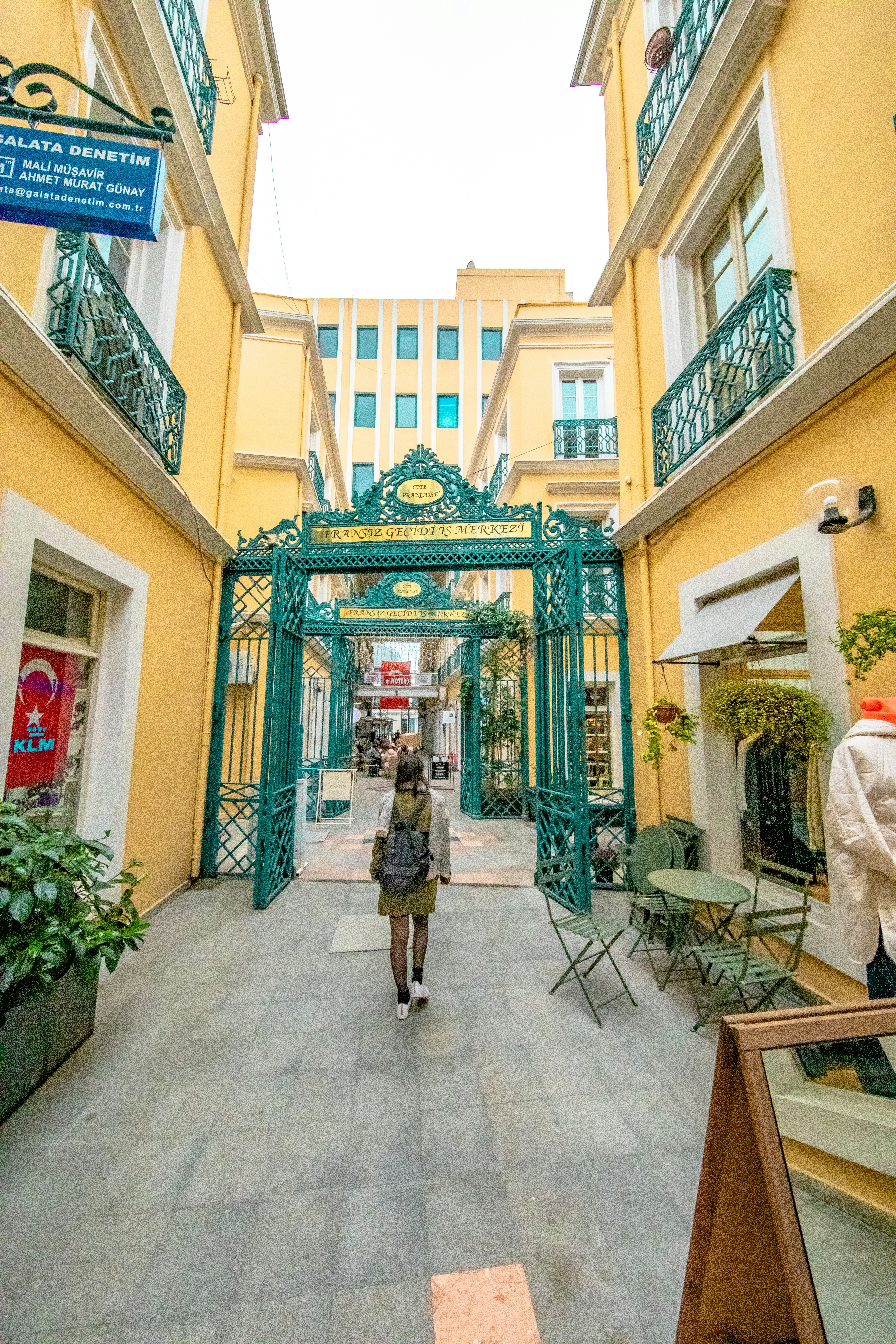 a woman walking down a walkway in front of a building